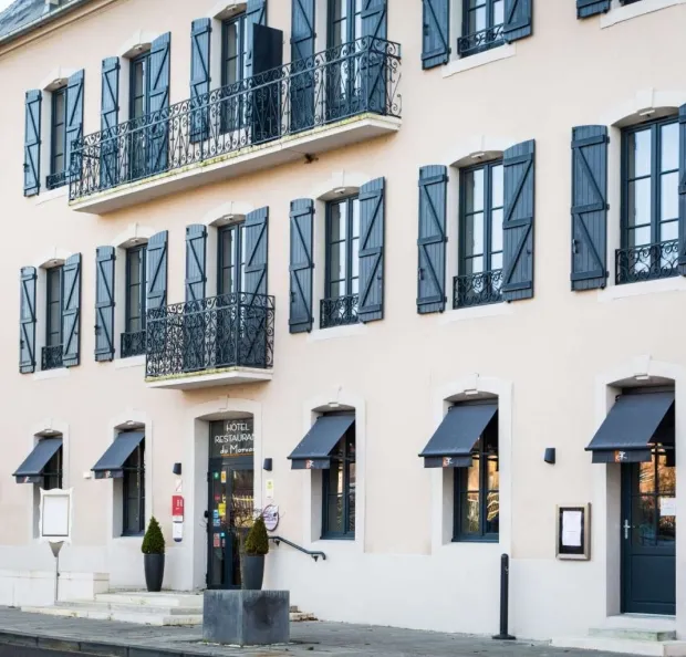 Élégant hôtel bourgeois avec balcons ouvragés et façade claire à Luzy.